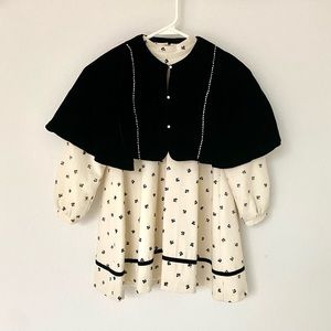 Girl’s ivory color dress with black velvet poncho.